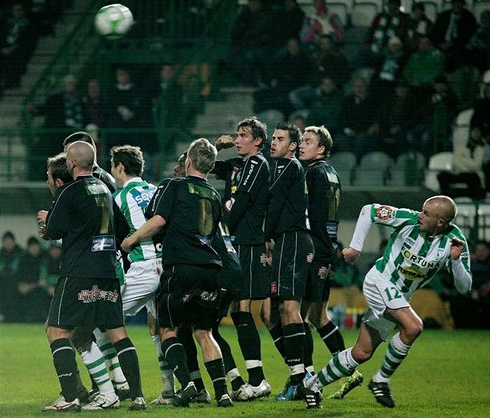 Kaufmanův přímý kop letí nad zdí.